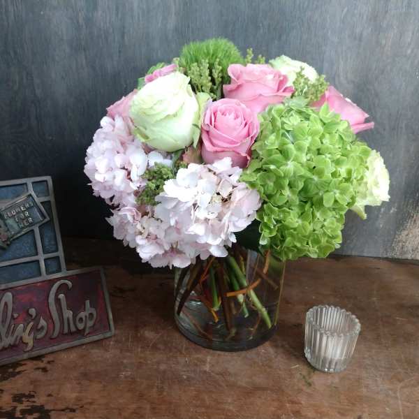 Pink and white roses with hydrangeas in a glass vase