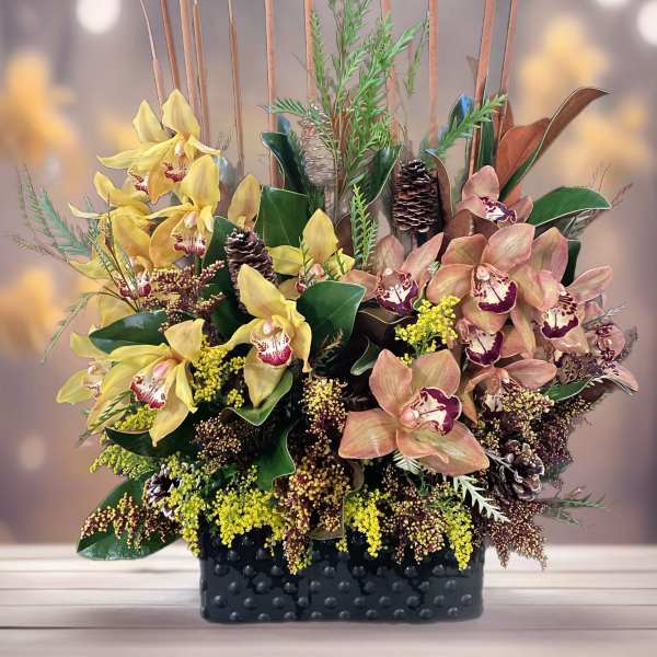 Arrangement of yellow and peach orchids in a black textured container