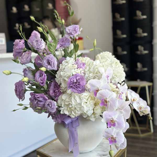 Lavender flowers and white hydrangeas in a round white vase