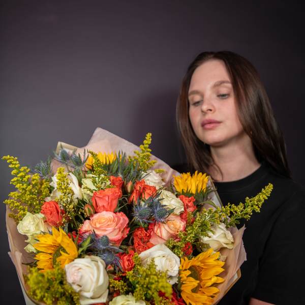 Large bouquet of roses and sunflowers wrapped in paper