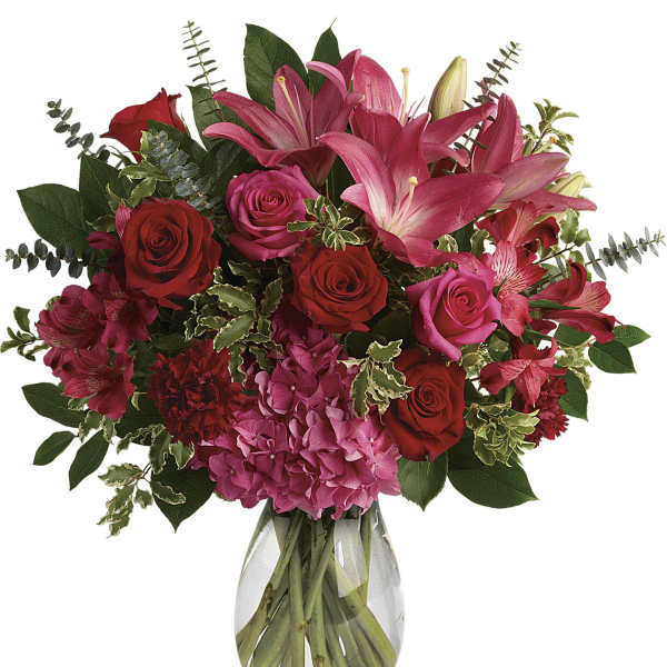 Bouquet of pink lilies and red roses in a clear glass vase