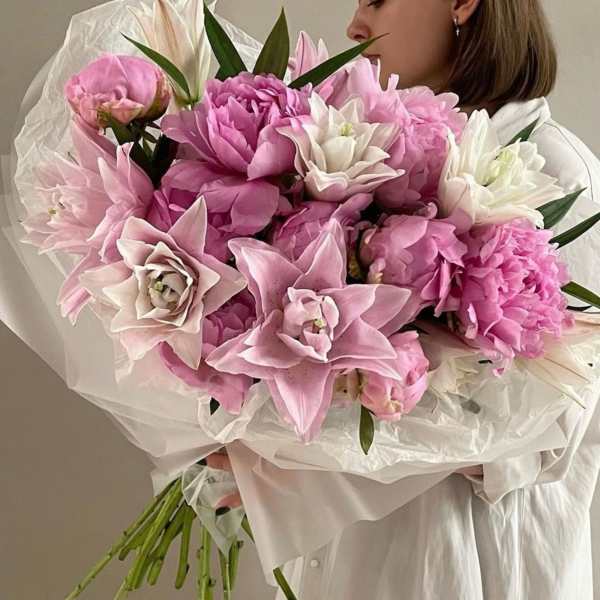 Woman holding a large bouquet of pink and white flowers