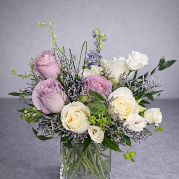 Bouquet of lavender and white roses in a clear glass vase
