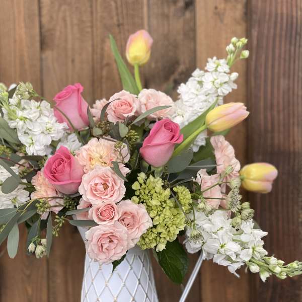 Pink and white flower arrangement in a white vase