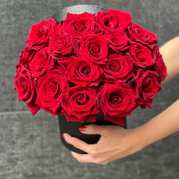 Handheld bouquet of red roses in a black box