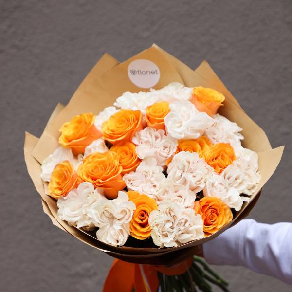 Bouquet of orange and white roses wrapped in brown paper
