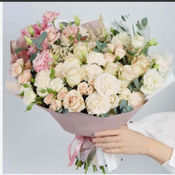 Large bouquet of pale pink and white roses with ribbon wrap