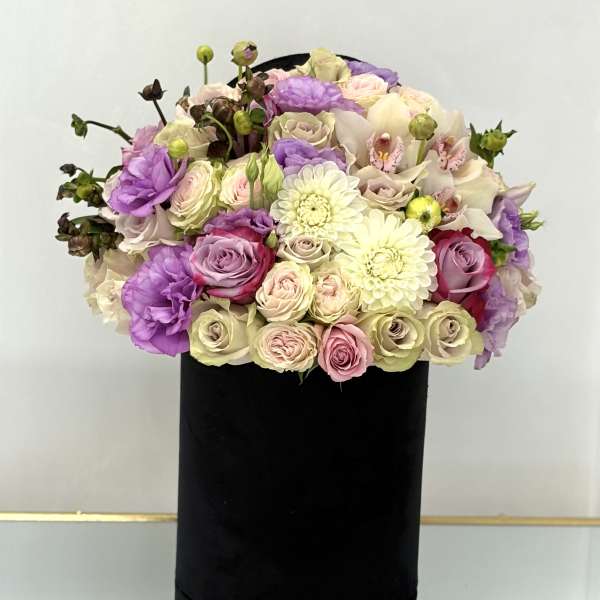 Bouquet of pastel roses, orchids, and white dahlias in a black box