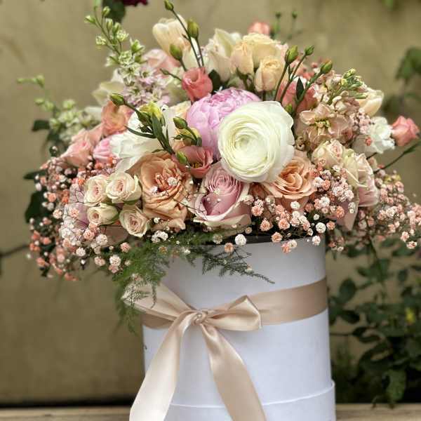Pastel flower arrangement in a white hat box with a satin ribbon
