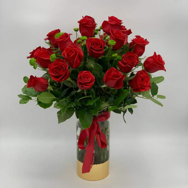 Bouquet of red roses in a glass vase with a red ribbon