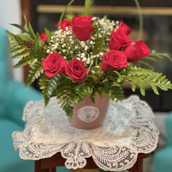 Pink rose arrangement in a small pot with baby's breath
