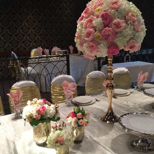 Pink and white floral centerpieces on a decorated banquet table
