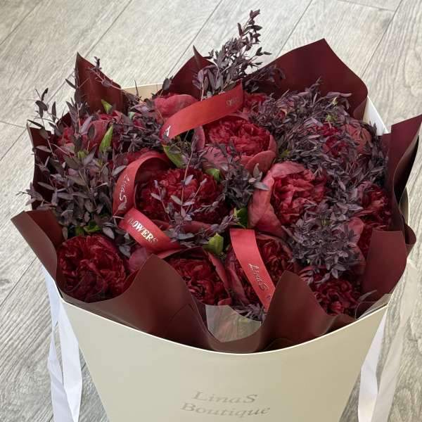 Bouquet of deep red flowers in a cream gift box