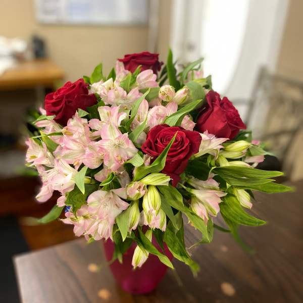 Bouquet of red roses and pale pink alstroemeria in a vase
