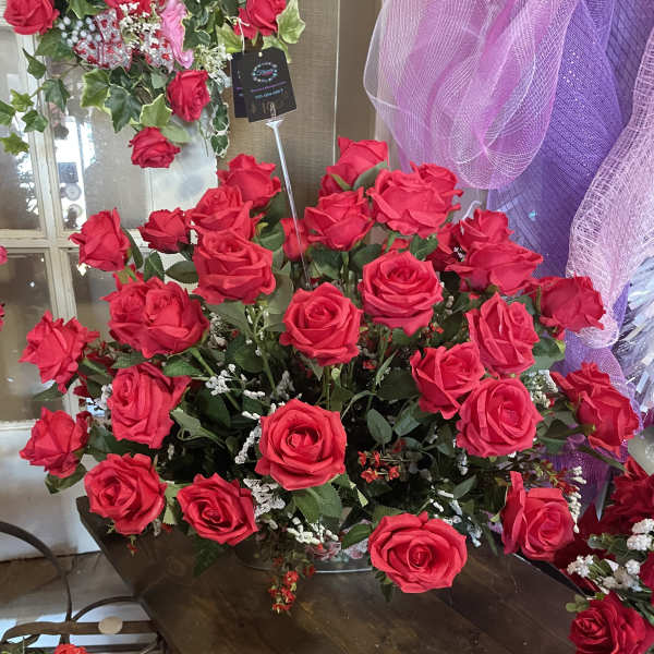 Large bouquet of bright red roses with purple mesh decor