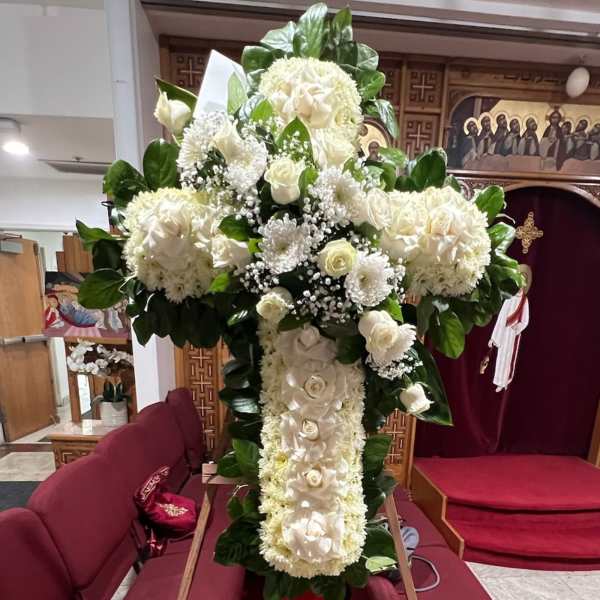 Large white floral cross arrangement with roses and chrysanthemums