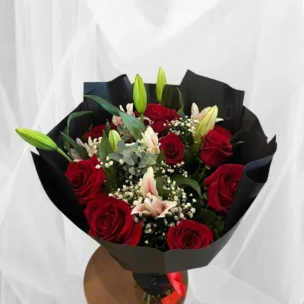 Bouquet of red roses and lilies wrapped in black paper