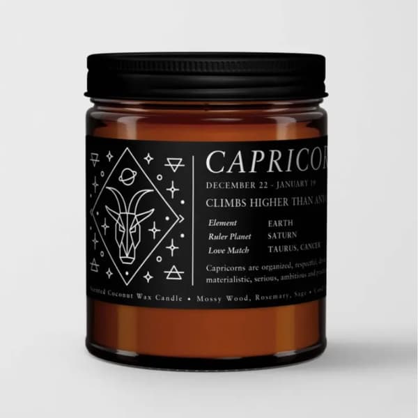 Amber candle in a black-lidded jar with a Capricorn label