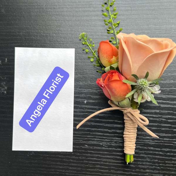 Small boutonniere with peach and orange roses tied with twine