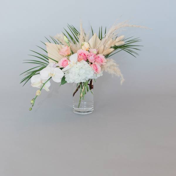 Pink roses and white orchids in a clear glass vase