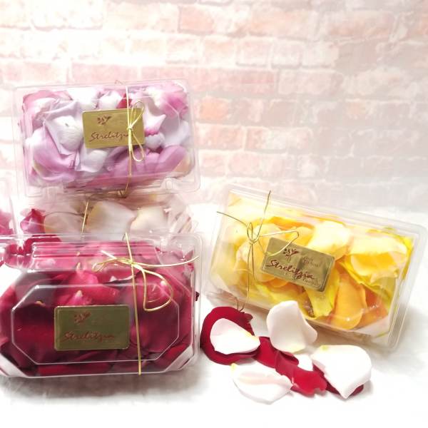 Plastic boxes filled with rose petals in pink, white, red, and yellow