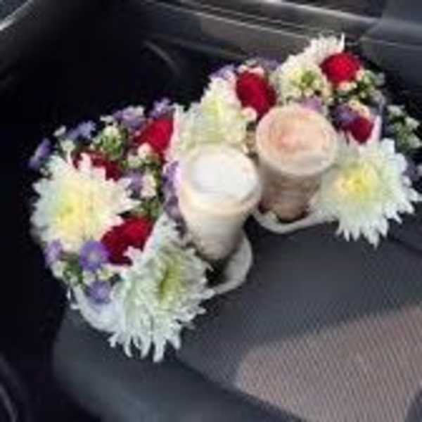 Two floral arrangements with white and red blooms on car seats