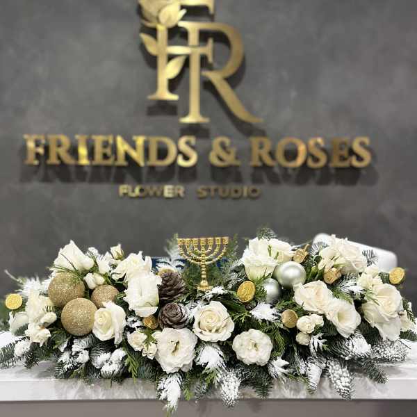 White floral centerpiece with gold ornaments and a menorah