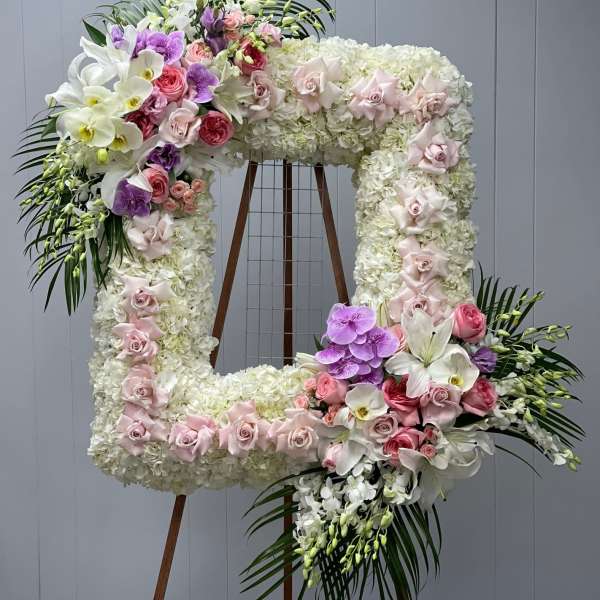 Large floral number-shaped arrangement with white, pink, and purple flowers