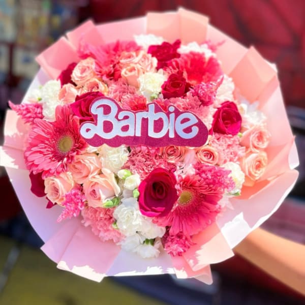 Pink and white bouquet with a Barbie sign