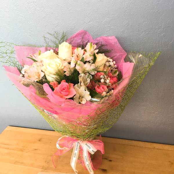 Pink and white bouquet with roses and alstroemeria wrapped in pink paper