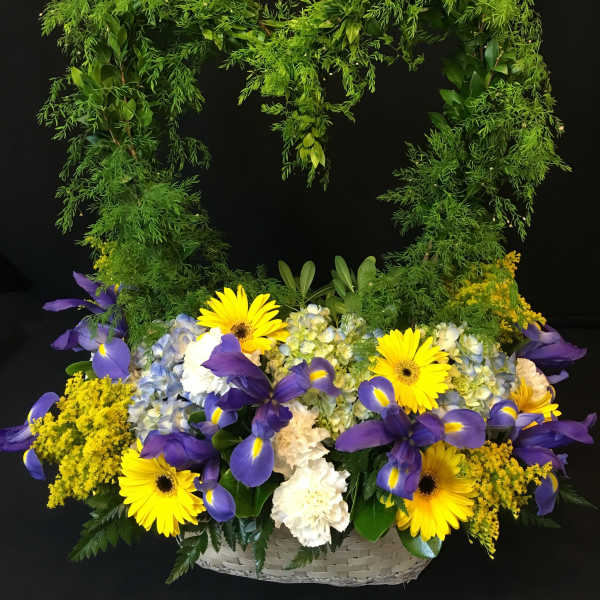 Basket arrangement with yellow daisies, purple irises, and blue hydrangeas