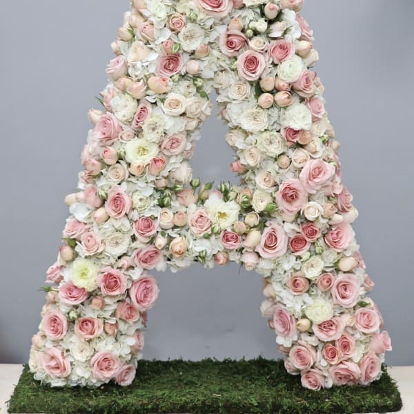 Large floral letter A covered in pink and white roses