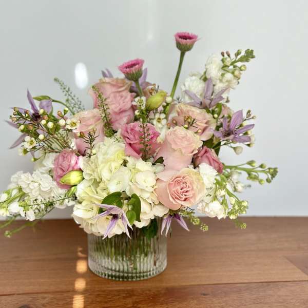 Pink and white floral arrangement in a clear glass vase