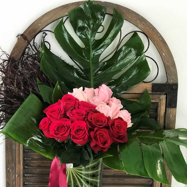 Bouquet of red and pink roses in a clear glass vase