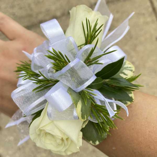 White rose wrist corsage with ribbon and greenery
