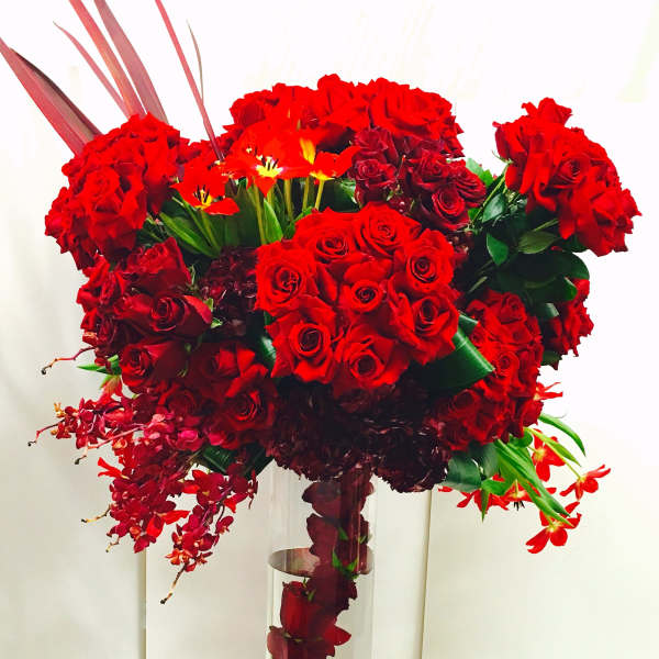Tall red rose arrangement in a clear glass vase