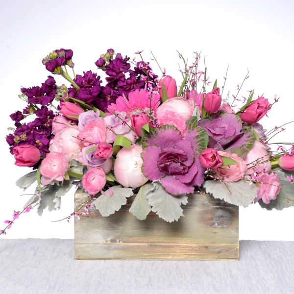 Pink and purple floral arrangement in a wooden box
