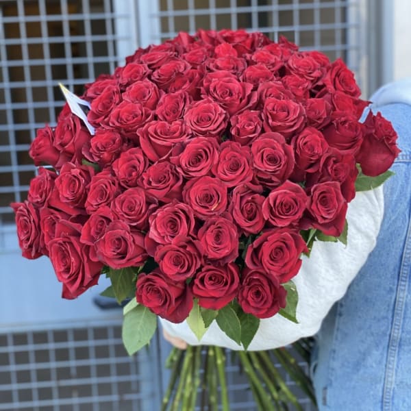 Large bouquet of red roses wrapped in white paper