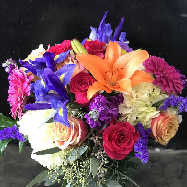 Colorful bouquet with roses, lilies, irises, and chrysanthemums in a vase