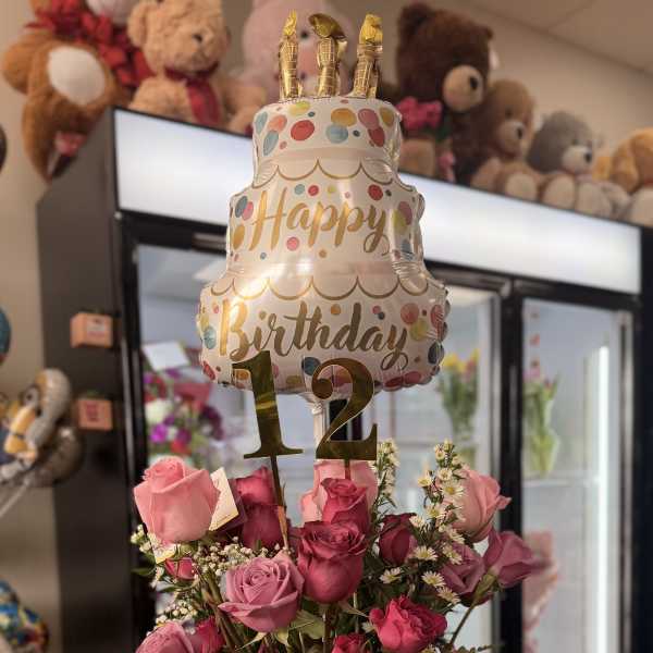Pink rose bouquet in a glass vase with a birthday balloon and number 12 topper