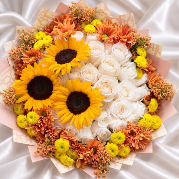 Bouquet of sunflowers, white roses, and orange chrysanthemums in pastel wrap