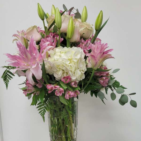 Pink lilies and white hydrangea in a clear glass vase