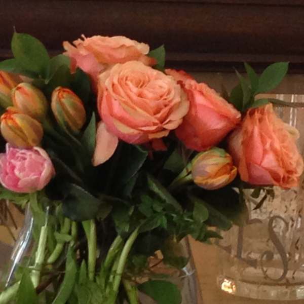 Bouquet of peach and pink roses in a clear glass vase