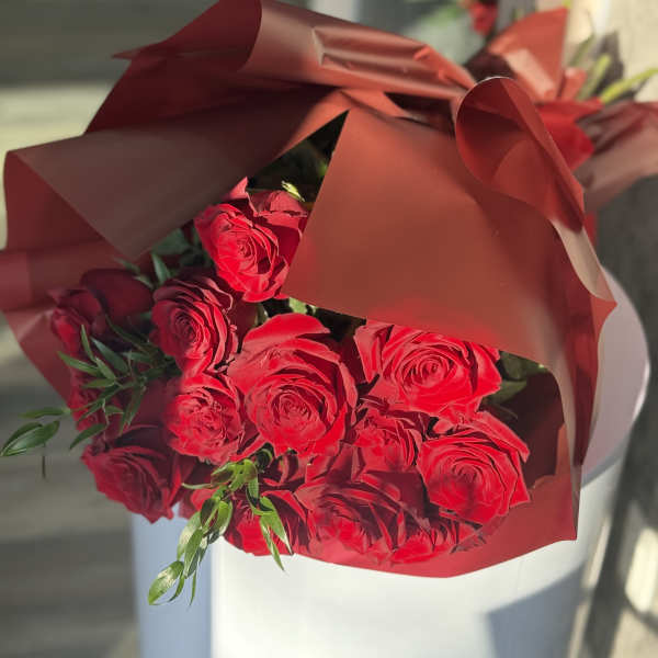 Bouquet of red roses wrapped in burgundy paper