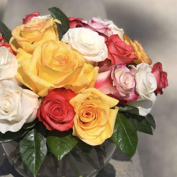 Bouquet of multicolored roses in a clear glass vase