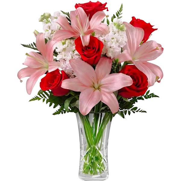 Bouquet of pink lilies and red roses in a clear glass vase