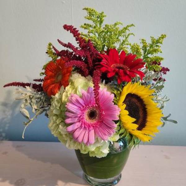 Colorful mixed bouquet in a glass vase with gerbera daisies and hydrangea