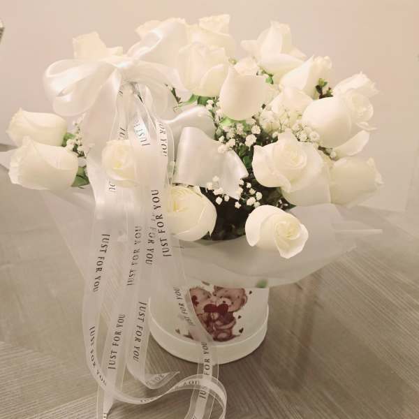 White rose bouquet in a round box with a ribbon