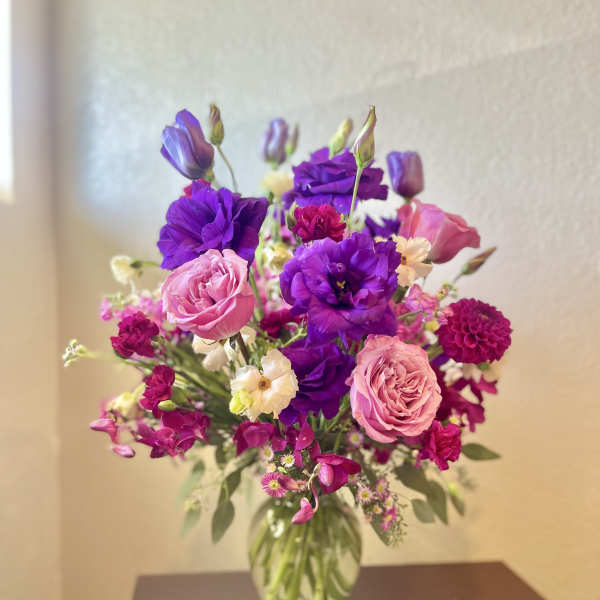 Bouquet of pink and purple flowers in a clear glass vase