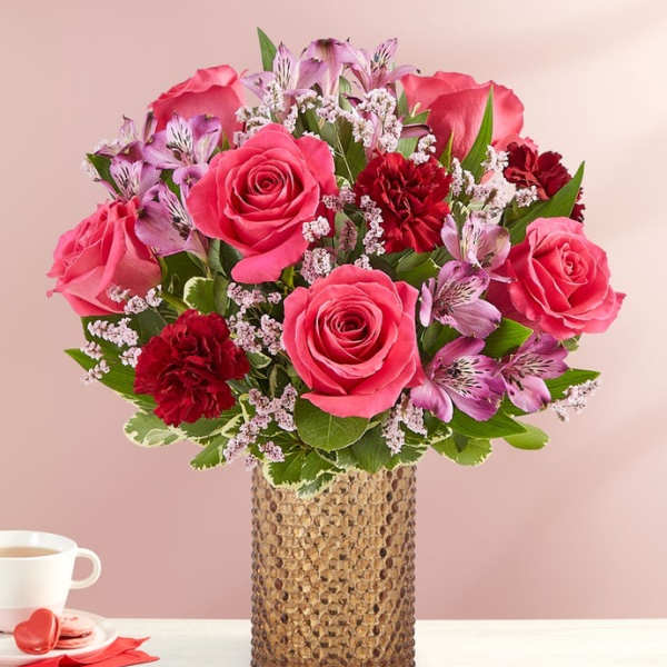 Pink roses and red carnations in a textured vase